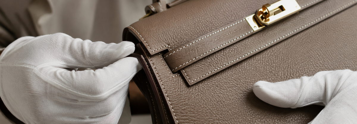 An expert closely inspecting the hardware and leather grain of a pre-owned luxury bag at LUX&MO